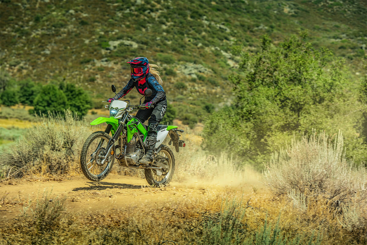 Three-quarter front angle of a person riding a motorcycle off-road.