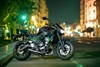 Side angle of a motorcycle parked at night in an urban city.