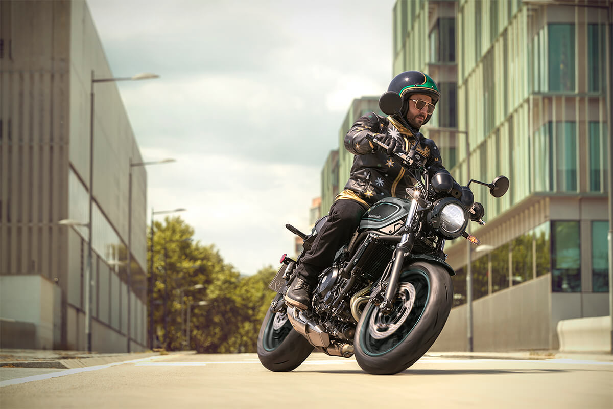 Three-quarter front angle of a person riding a motorcycle in an urban city.