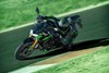 Three-quarter front angle of a motorcycle making a sharp turn on a track.