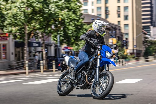 Three-quarter front angle of a person making a turn on a motorcycle in an urban city. opens in a new window