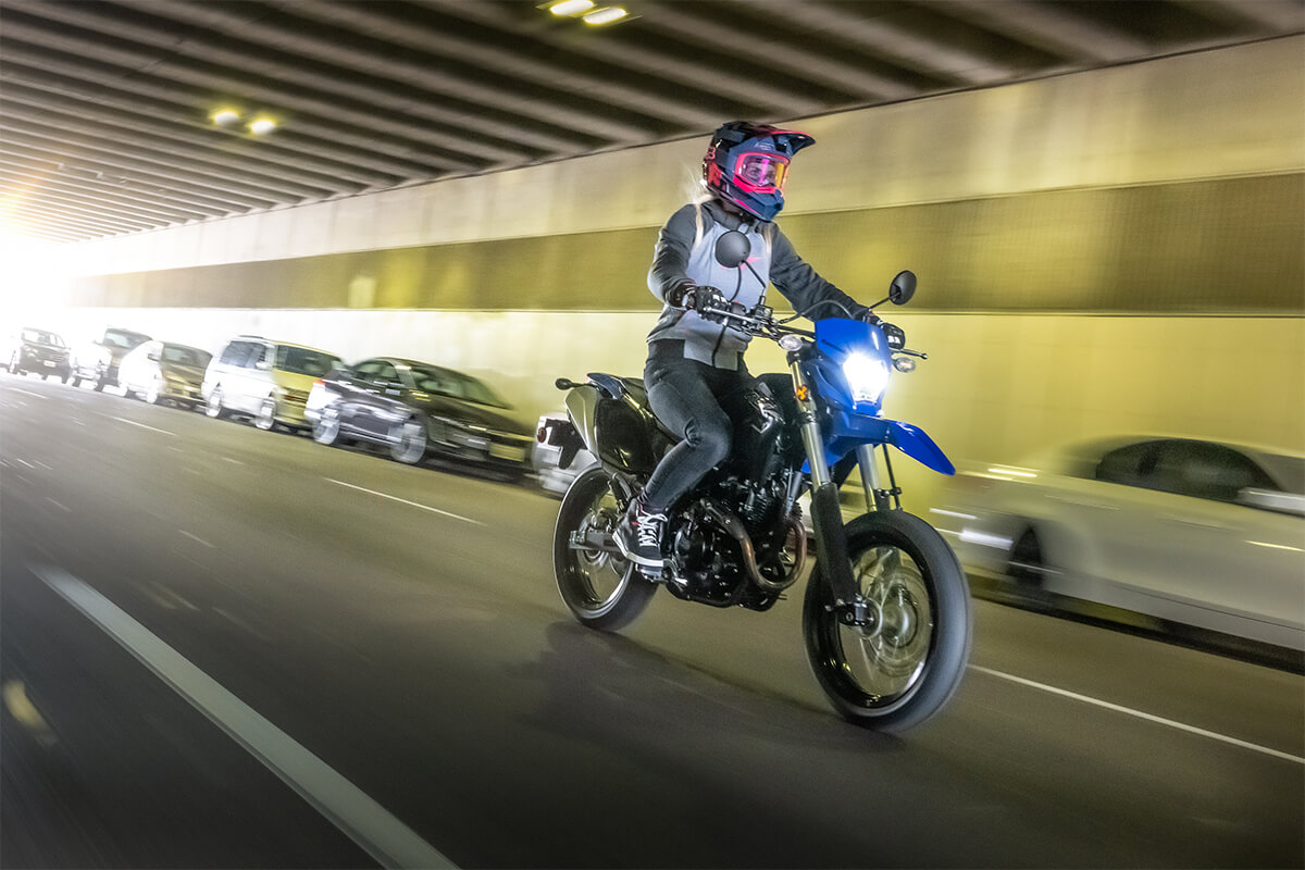 Three-quarter front angle of a person riding a motorcycle in a tunnel.