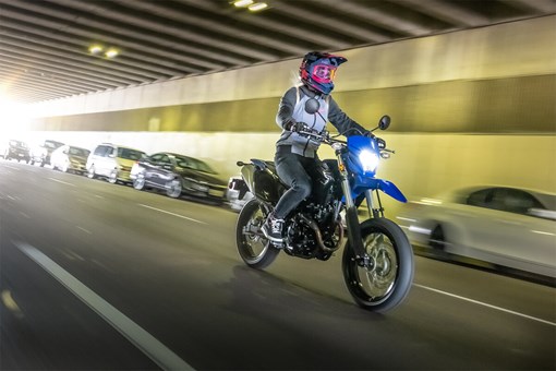 Three-quarter front angle of a person riding a motorcycle in a tunnel. opens in a new window