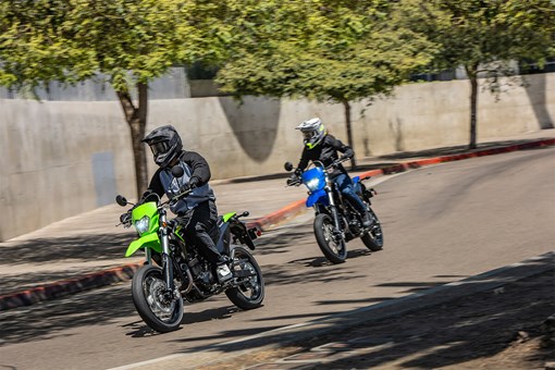 Three-quarter front angle of two motorcyclist riding in an urban city. opens in a new window