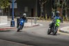 Three-quarter front angle of two motorcyclist making a turn in an urban city.