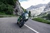 Front angle of a person riding a motorcycle through the mountains.