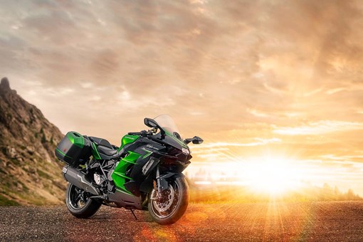 Three-quarter front angle of a motorcycle staged off-road in front of a sunset. opens in a new window