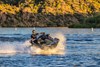 Three-quarter front angle of a person making a sharp turn on a personal watercraft on the water.