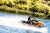 Side angle of a person making a sharp turn on a personal watercraft on the water.