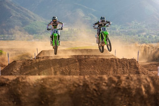 Front angle of two riders riding a motorcycle through the whoops on a dirt track. opens in a new window