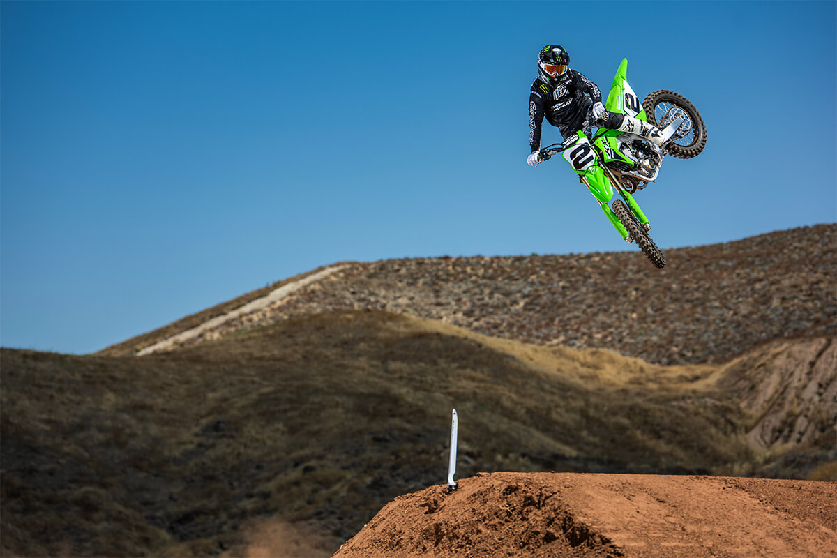 Three-quarter front angle of a person making a jump on a motorcycle off-road.