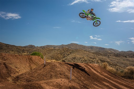 Side angle of a person mid air on a motorcycle off-road. opens in a new window
