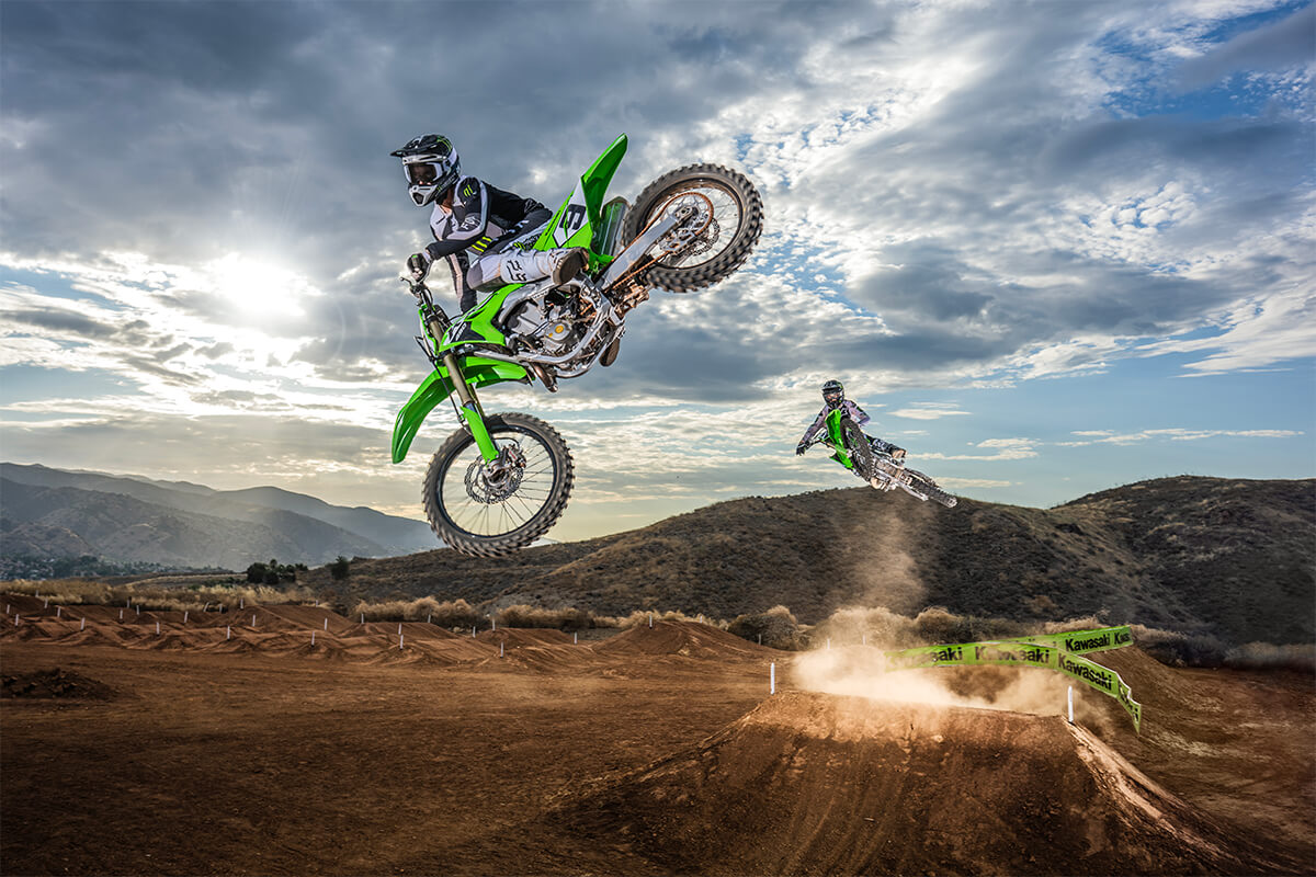 Front angle of two riders making a jump off-road.