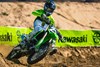 Three-quarter front angle of a person riding a motorcycle through a corner on track.