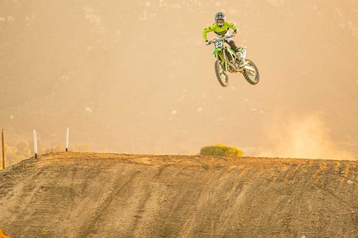 Three-quarter front angle of a motorcycle in the air on a track.  opens in a new window