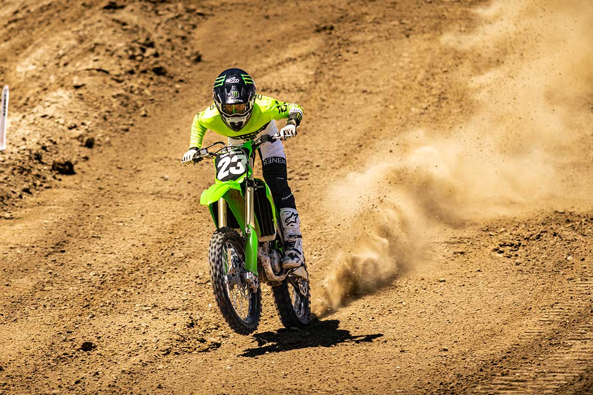 Front angle of a person doing a wheelie on a motorcycle on a track.