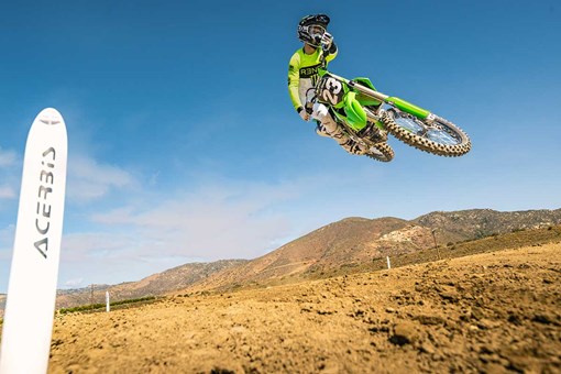 Three-quarter front angle of a motorcycle jumping over the camera on track. opens in a new window