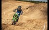 Front angle of a person riding a motorcycle through the whoops on a track.