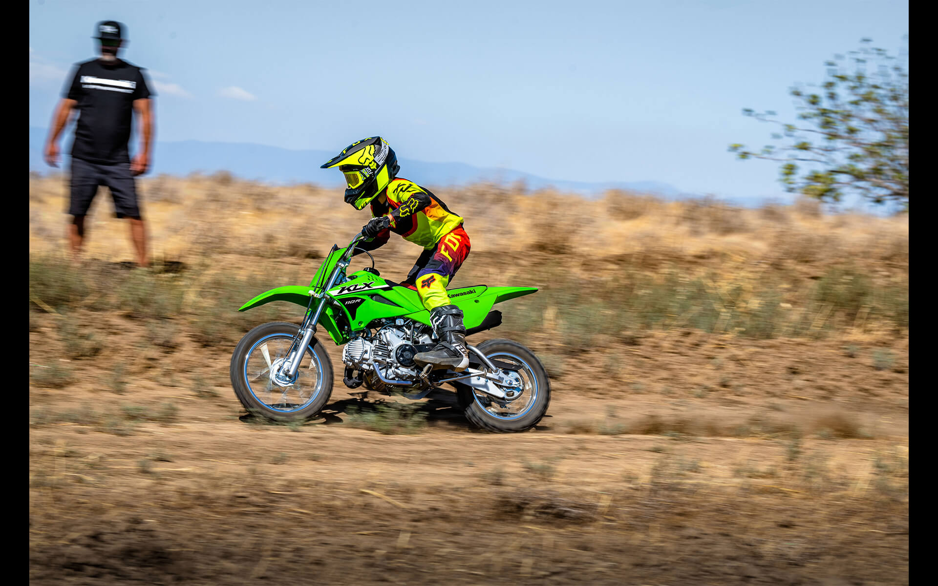 Side angle of a person riding a motorcycle off-road.