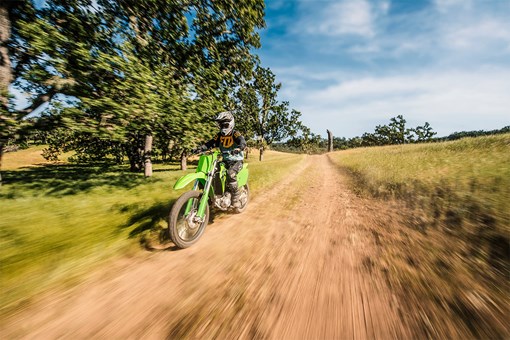 Three-quarter front angle of a person riding a motorcycle off-road. opens in a new window