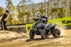 Front three-quarter angle of a person riding an ATV on a track.