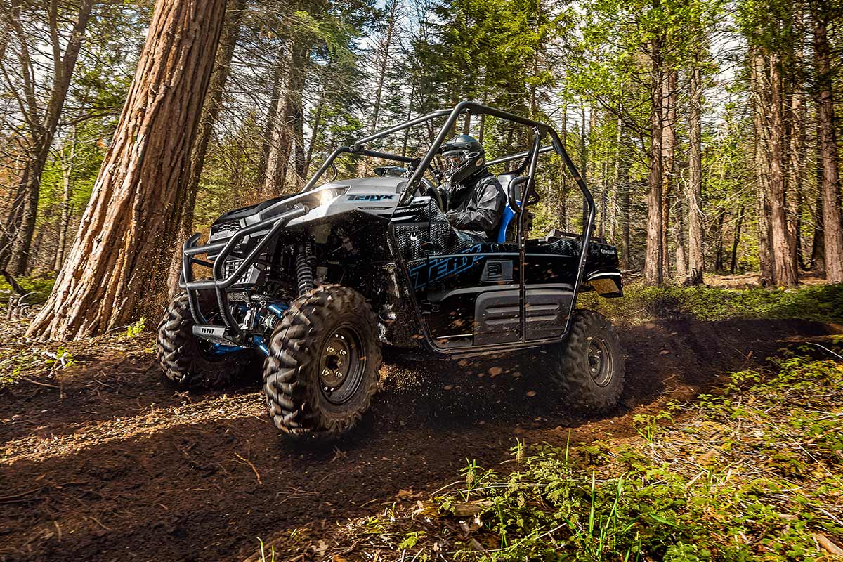 Side angle of a person and passenger driving a side x side off-road.