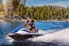 Three-quarter front angle of two people on a personal watercraft on the water.