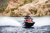 Front angle of a person riding a personal watercraft on the water.
