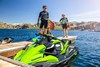 Three-quarter front angle of two people standing near a personal watercraft.