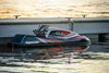 Side angle of a personal watercraft parked near a dock.