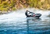 Side angle of a person on a personal watercraft on the water.