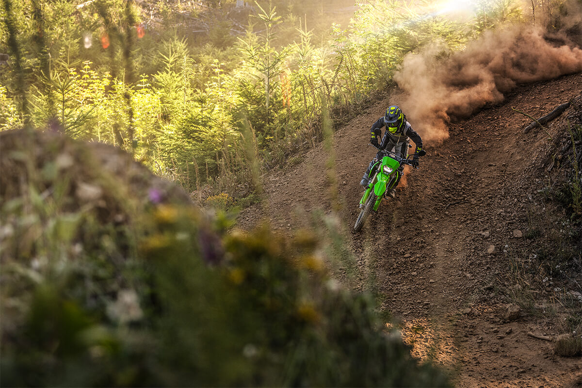 Front angle of a person making a sharp turn on a motorcycle off-road.