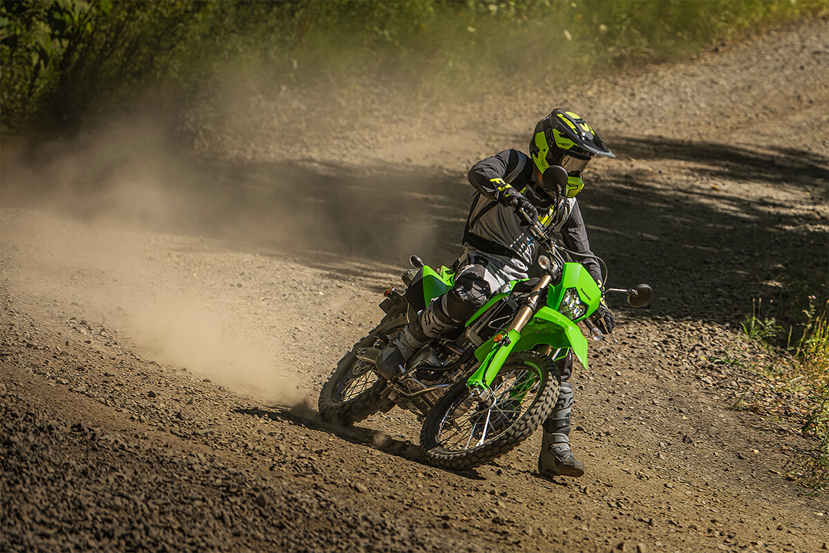 Three-quarter front angle of a person riding a motorcycle off-road.