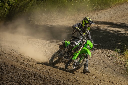 Three-quarter front angle of a person riding a motorcycle off-road. opens in a new window