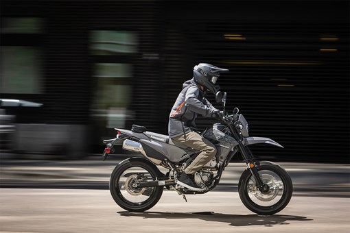 Side angle of a person riding a motorcycle on a city street. opens in a new window