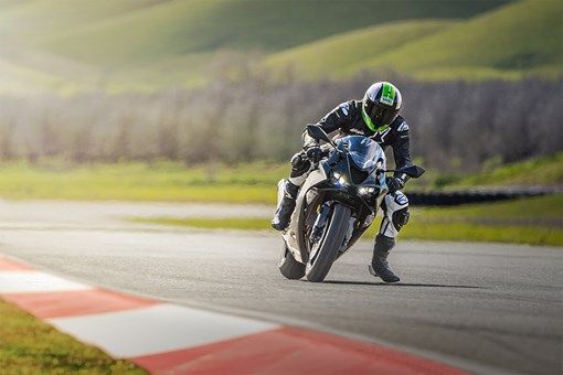 Front angle of a person on a motorcycle preparing for a turn on a track. opens in a new window