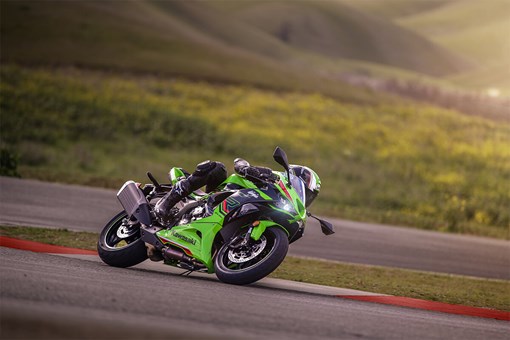 Profile angle of a person on a motorcycle leaning into a corner on a track. opens in a new window