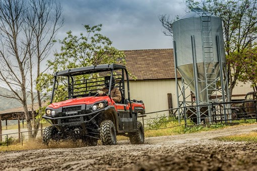 Three-quarter front angle of a person driving a side x side off-road. opens in a new window