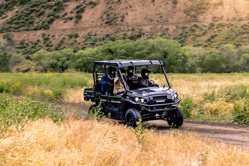 Three-quarter front angle of a person driving a side x side off-road. opens in a new window