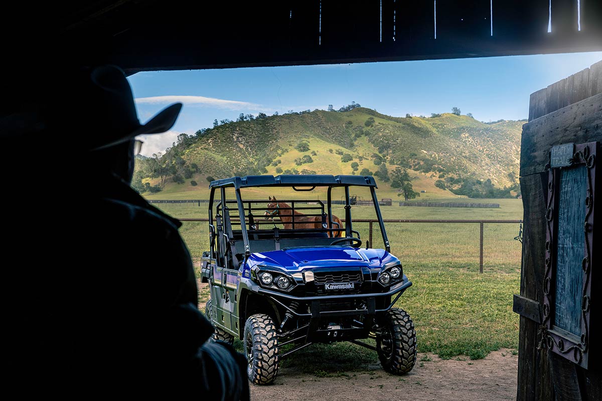 Three-quarter front angle of a parked side x side off-road with hills in the background.