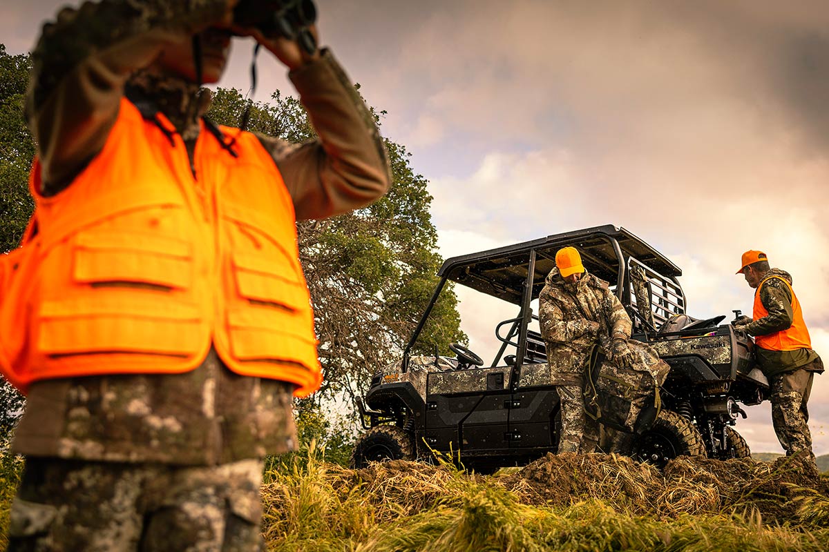 Three-quarter rear angle of a person unloading a side x side off-road.