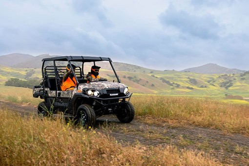 Three-quarter front angle of a person driving a side x side off-road. opens in a new window