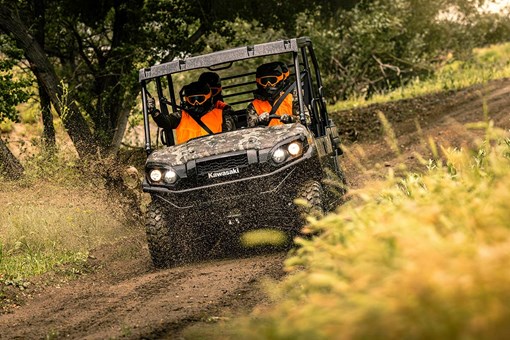 Front angle of a person driving a side x side with three passengers off-road. opens in a new window