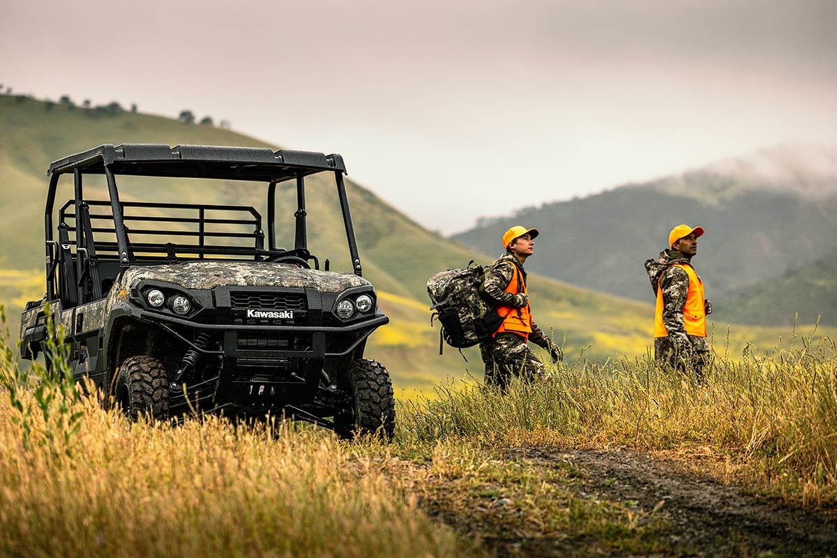 Three-quarter front angle of two people walking away from a parked side x side off-road.