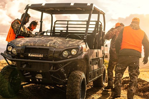 Three-quarter front angle of four people exiting a side x side off-road. opens in a new window
