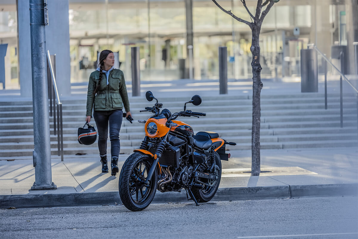 Three-quarter front angle of a person next to a motorcycle.