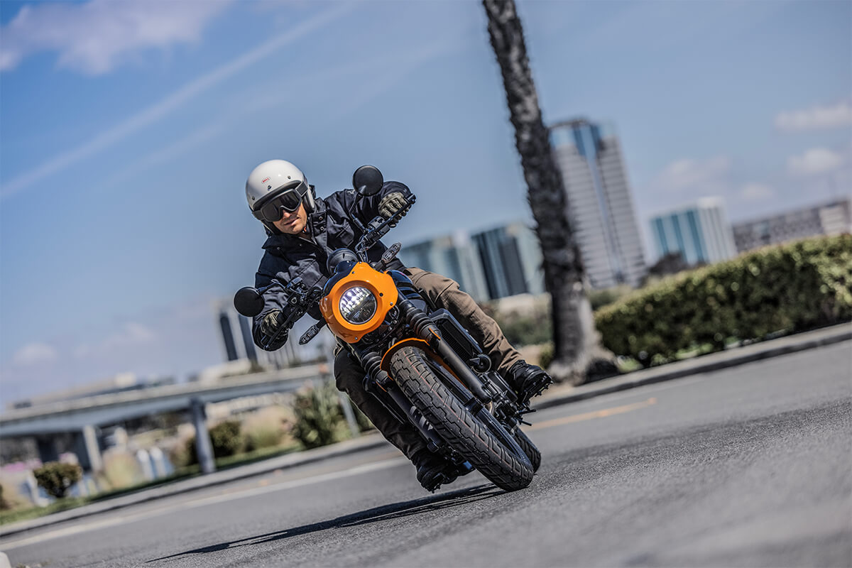 Front angle of a person riding a motorcycle on a city street.