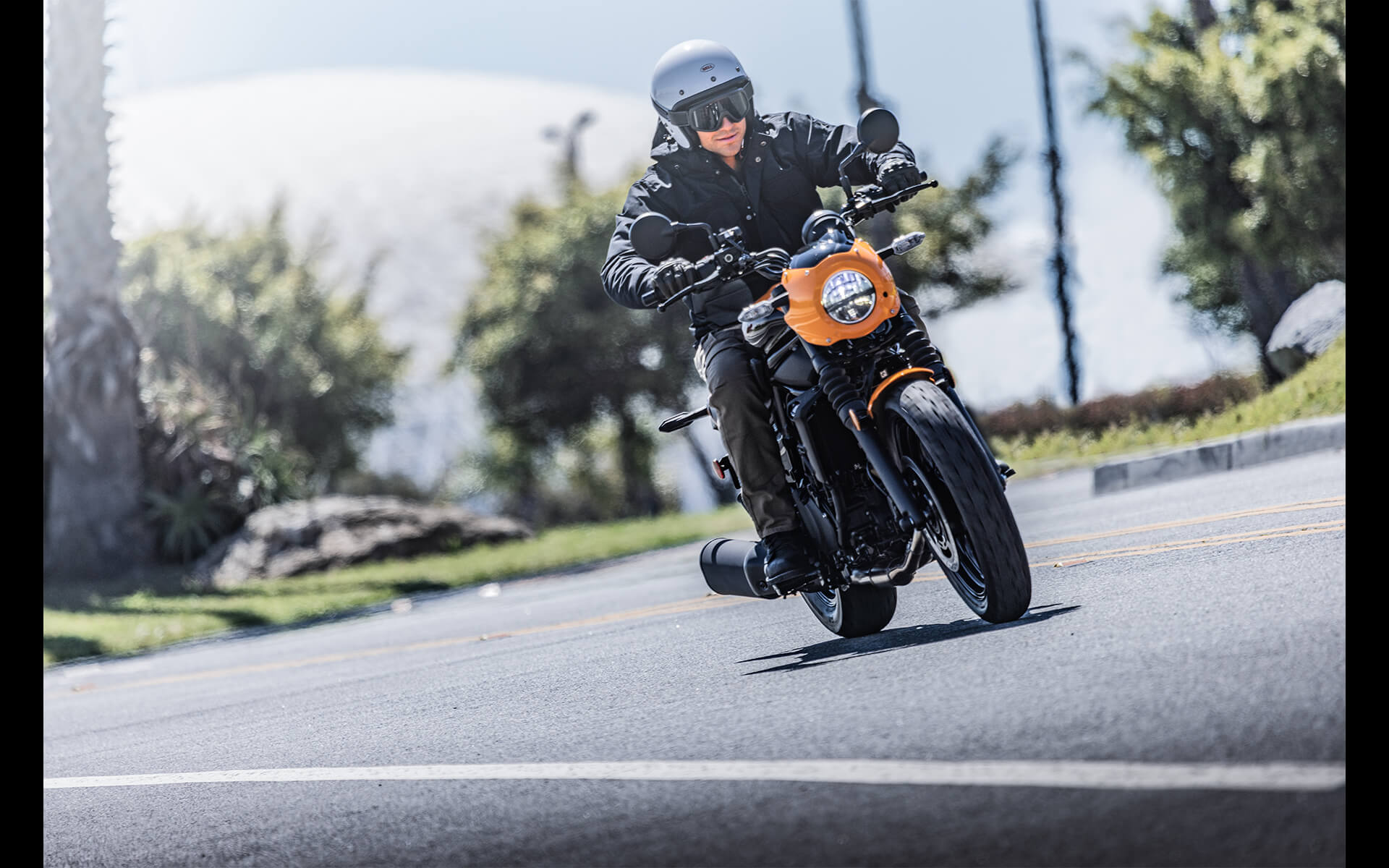 Front angle of a person riding a motorcycle in the city.