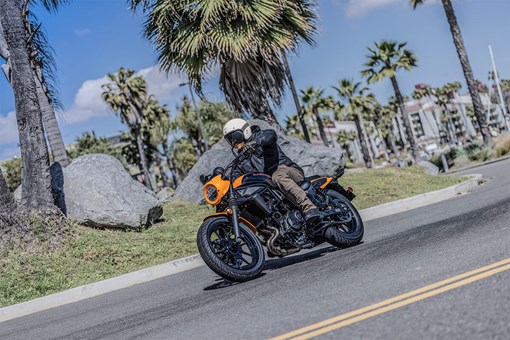 Three-quarter front angle of a person riding a motorcycle on the street. opens in a new window