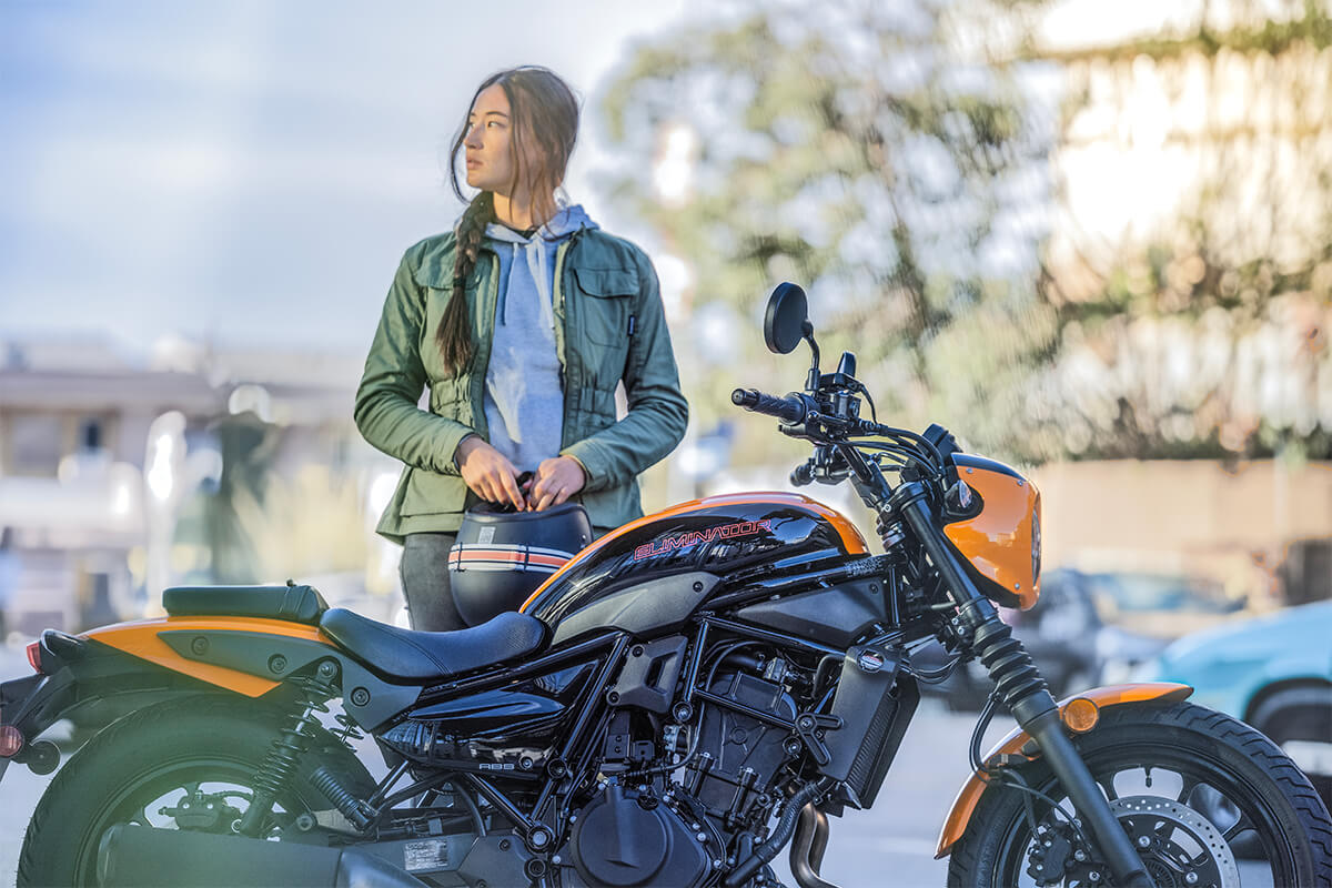 Profile angle of a person standing next to a motorcycle.